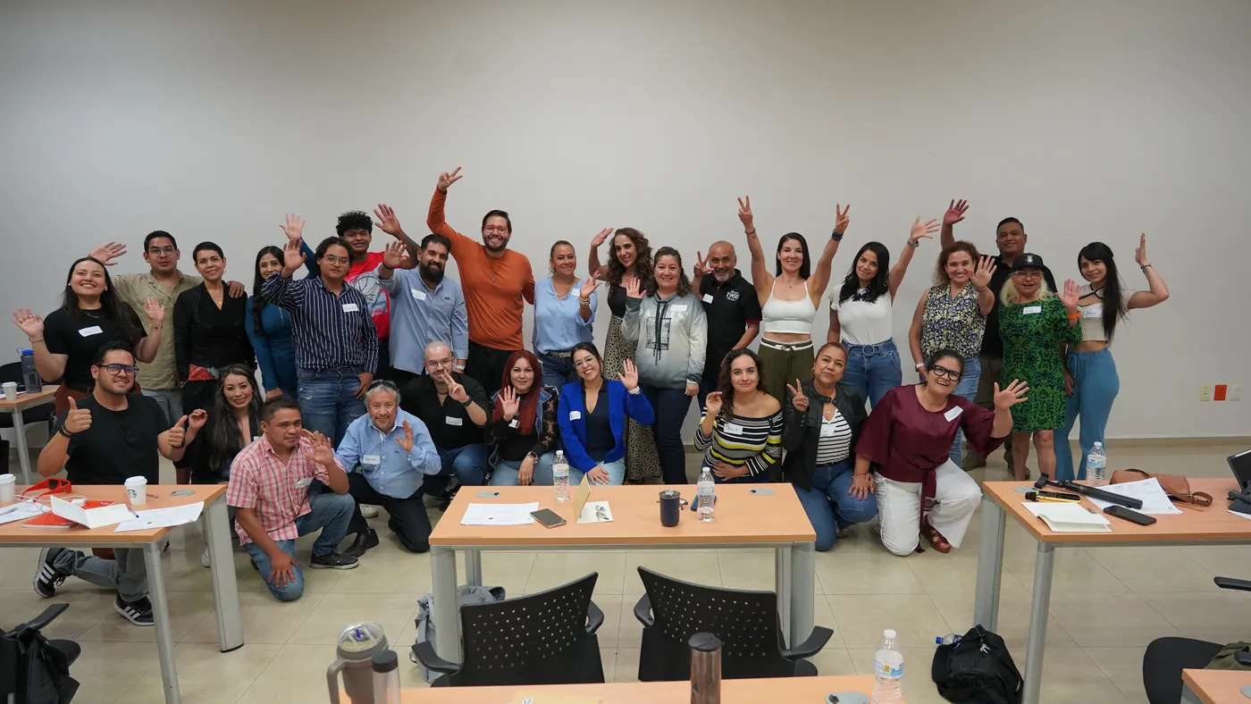 Grupo de asistentes levantando las manos al terminar un taller de Rafa